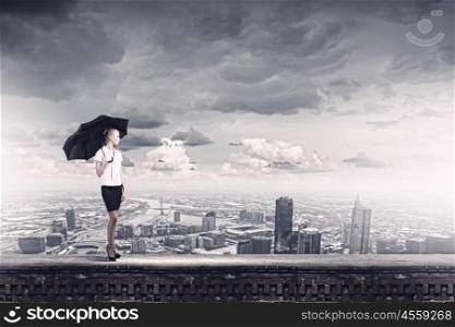 Businesswoman on top. Young business lady on top of building with umbrella