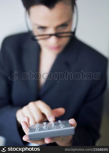 Businesswoman operating a calculator