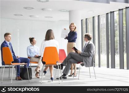 Businesswoman planning strategy with colleagues during meeting at office