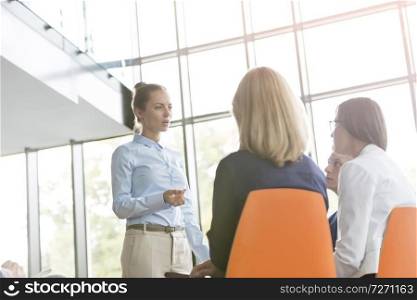 Businesswoman planning with colleagues during meeting at new office