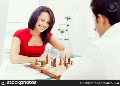 Businesswoman playing chess in office. Strategic play