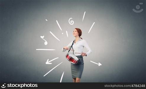 Businesswoman playing drums. Young businesswoman on color background playing drums