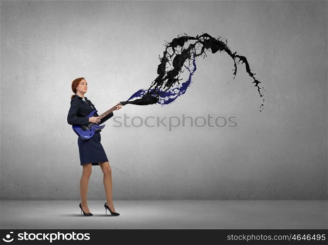 Businesswoman playing guitar. Cheerful businesswoman playing electric guitar on cement background