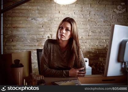 Businesswoman portrait at indoor office sitting with brickwall background