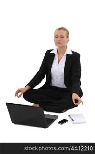 Businesswoman practicing yoga in front of her laptop