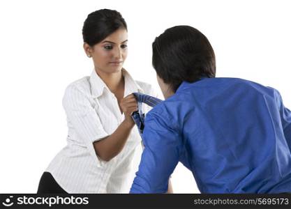 Businesswoman pulling a businessman&rsquo;s tie