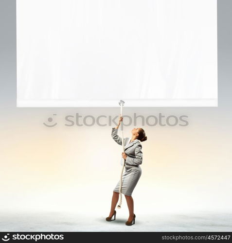 Businesswoman pulling banner. Image of businesswoman pulling blank banner. Place for text