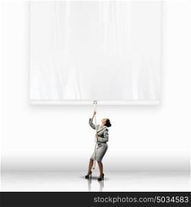 Businesswoman pulling banner. Image of businesswoman pulling blank banner. Place for text