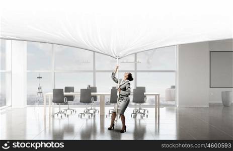 Businesswoman pulling banner. Young businesswoman in office and blank banner. Place for text