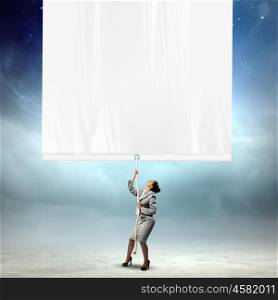 Businesswoman pulling blank banner. Image of young businesswoman pulling blank banner. Place for text