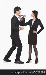 Businesswoman pulling businessman&rsquo;s tie
