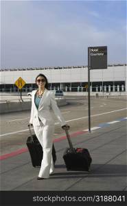 Businesswoman pulling her luggage outside an airport