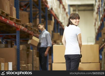 Businesswoman Pulling Pallet In Warehouse