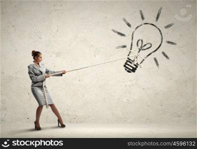 Businesswoman pulling rope. Image of attractive businesswoman pulling rope with idea symbol