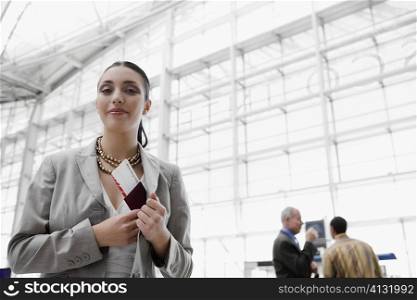 Businesswoman putting a passport with an airplane ticket in her coat&acute;s pocket
