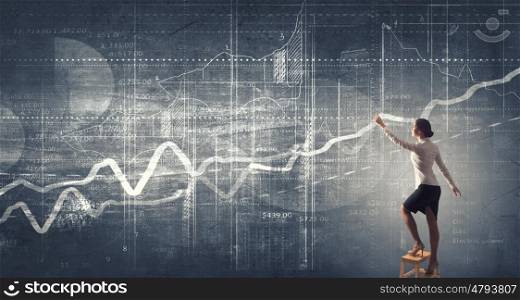 Businesswoman reaching idea. Back view of businesswoman standing on chair and reaching infographs on wall