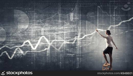 Businesswoman reaching idea. Back view of businesswoman standing on chair and reaching infographs on wall