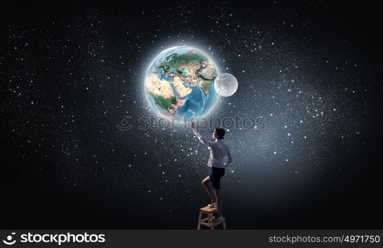 Businesswoman reaching planet in sky. Businesswoman standing on chair and reaching Earth planet. Elements of this image are furnished by NASA