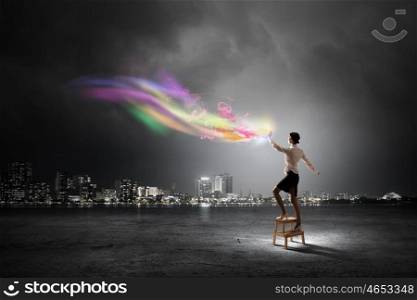 Businesswoman reaching success. Businesswoman standing on chair and reaching colorful light