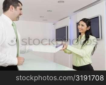 Businesswoman receiving a parcel from a businessman
