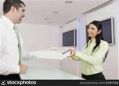 Businesswoman receiving a parcel from a businessman