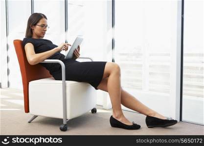 Businesswoman Relaxing With Digital Tablet During Break