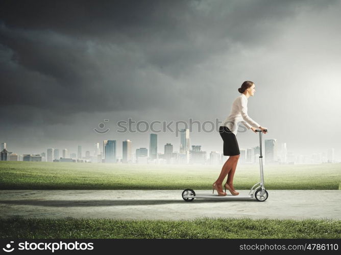 Businesswoman riding a scooter. Image of attractive businesswoman riding a scooter