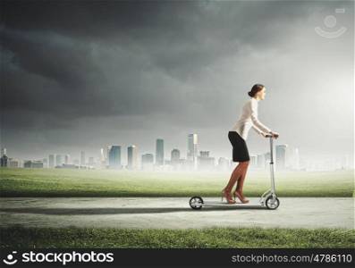 Businesswoman riding a scooter. Image of attractive businesswoman riding a scooter
