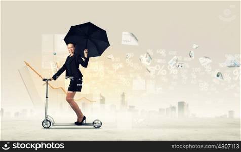 Businesswoman riding scooter. Image of young businesswoman in black riding scooter