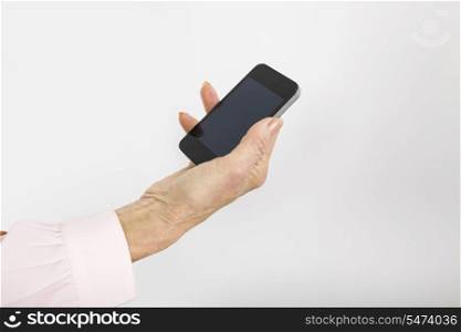 Businesswoman&rsquo;s hand holding smart phone in office