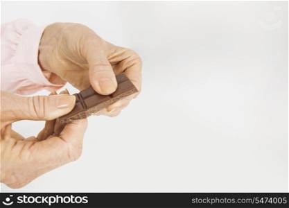 Businesswoman&rsquo;s hands holding chocolate bar in office