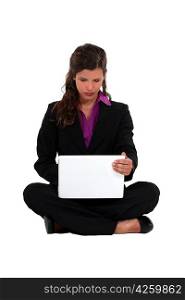 Businesswoman sat barefoot with laptop
