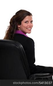 Businesswoman sat on office chair with her back turned