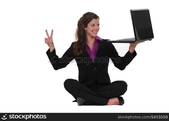Businesswoman sat on the floor making peace sign