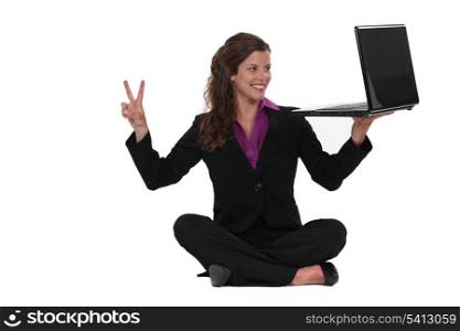 Businesswoman sat on the floor making peace sign