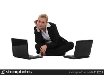 Businesswoman sat on the floor with two laptops