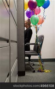 Businesswoman sat with bunch of balloons