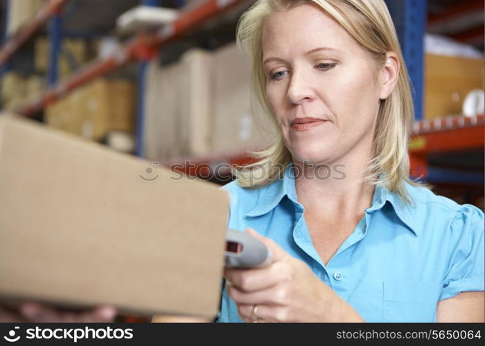 Businesswoman Scanning Package In Warehouse