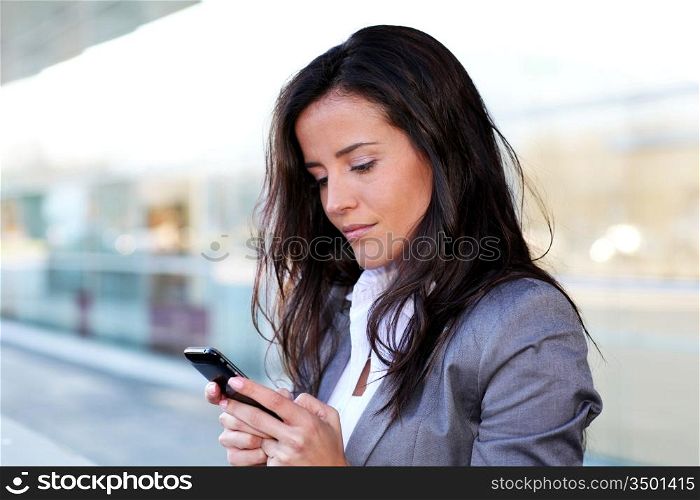 Businesswoman sending message with smartphone