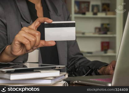 businesswoman shopping online with a laptop on the table using a credit card to buy online.