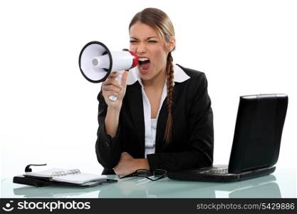 businesswoman shouting angrily with loudspeaker and laptop