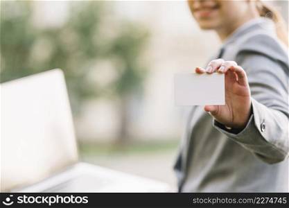 businesswoman showing business card outdoors