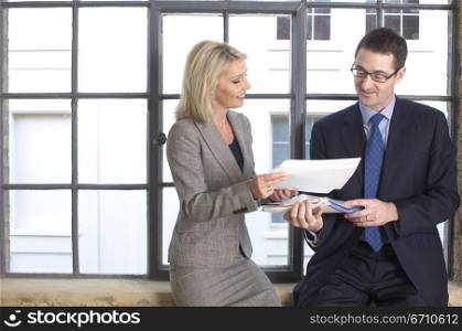 Businesswoman showing documents to a businessman