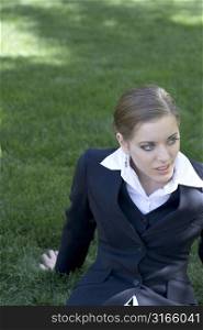 Businesswoman sitting and relaxing in the park with her business suit on