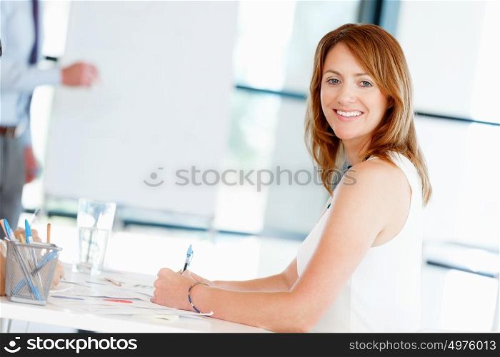 Businesswoman sitting and smiling at camera