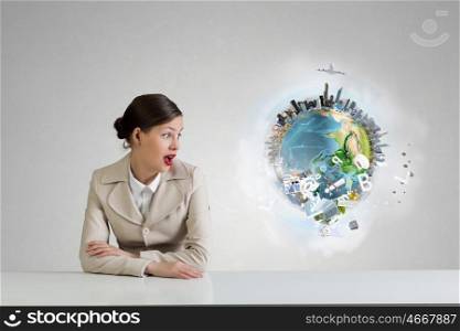 Businesswoman sitting at desk. Emotional attractive businesswoman sitting at table in office. Elements of this image are furnished by NASA