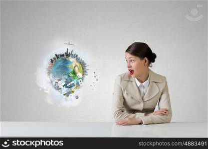 Businesswoman sitting at desk. Emotional attractive businesswoman sitting at table in office. Elements of this image are furnished by NASA