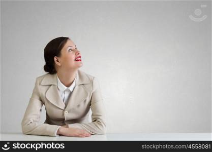 Businesswoman sitting at desk. Happy attractive businesswoman sitting at table in office