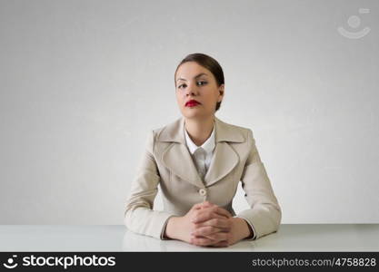 Businesswoman sitting at desk. Happy attractive businesswoman sitting at table in office