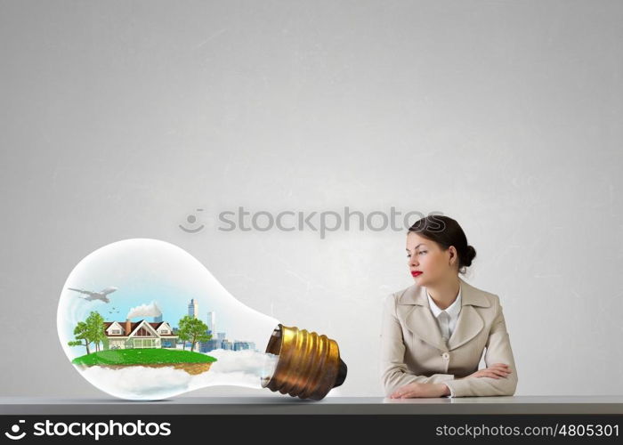 Businesswoman sitting at desk. Happy attractive businesswoman sitting at table in office